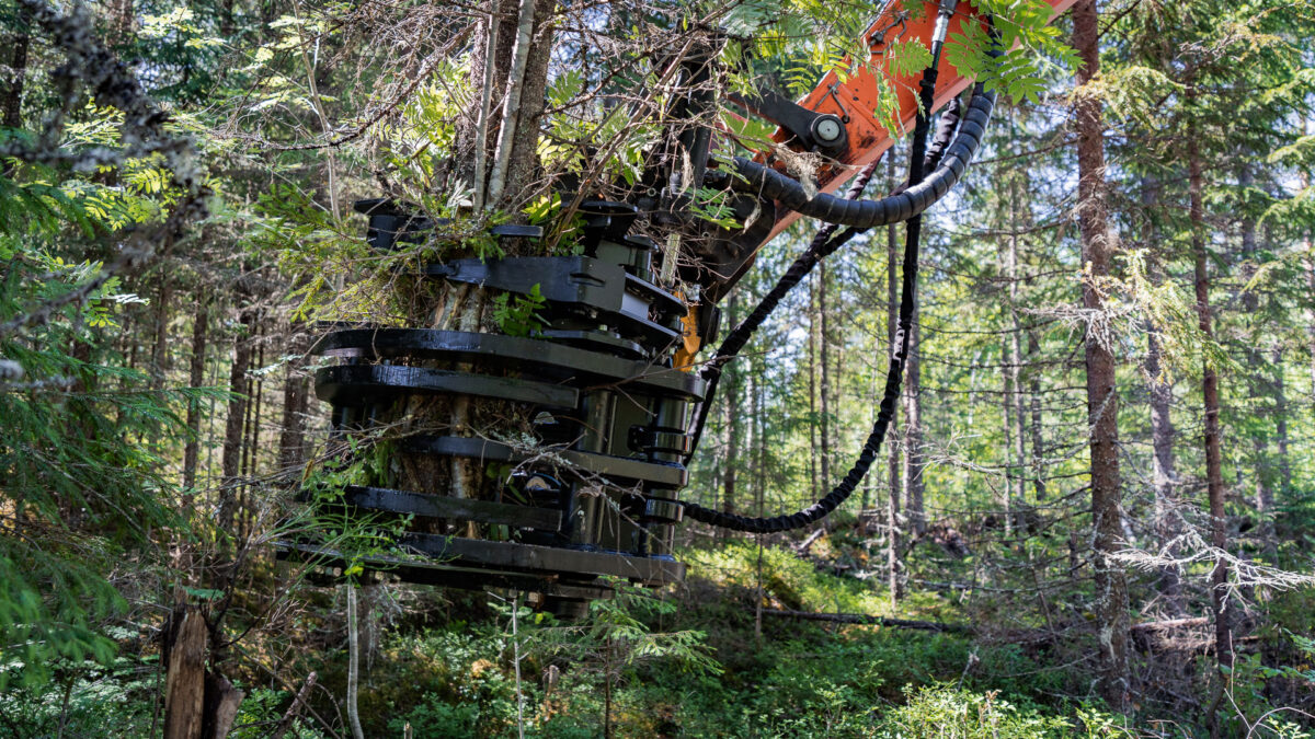 Grappin coupeur d'énergie JAK-300B attaché à la pelleteuse, avec les arbres dégagés fermement dans le grappin.