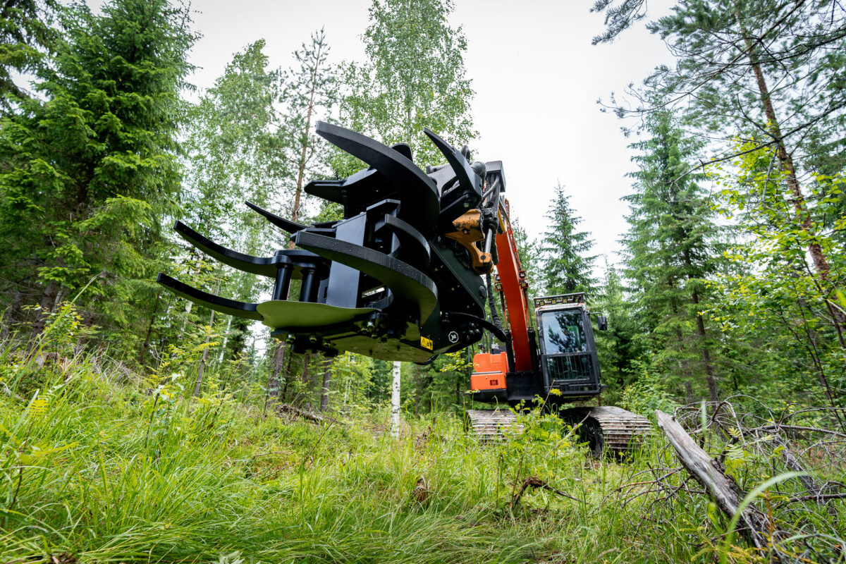 Grappin coupeur d'énergie JAK-300B attaché à une pelleteuse, travaillant dans la forêt.